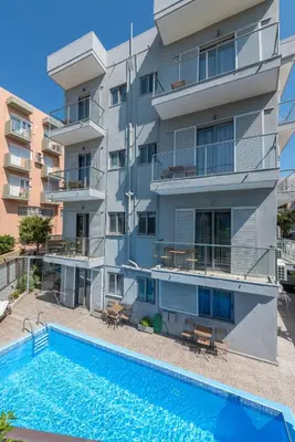 an apartment building with a swimming pool in front of it at 7Palms in Rhodes Town