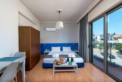 a hotel room with a bed and a table with a table at 7Palms in Rhodes Town