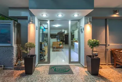 a lobby with two potted plants and a hallway at 7Palms in Rhodes Town