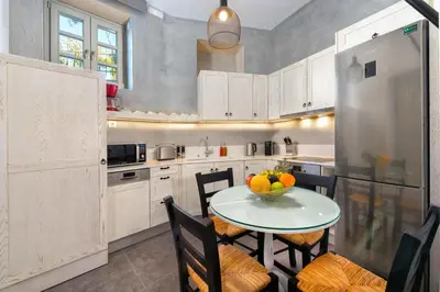 a kitchen with a table with a bowl of fruit on it at Lindos Shore Summer House with Jacuzzi and sea view !!! in Líndos