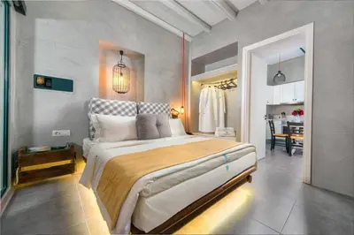 a bedroom with a large bed and a dining room at Lindos Shore Summer House with Jacuzzi and sea view !!! in Líndos