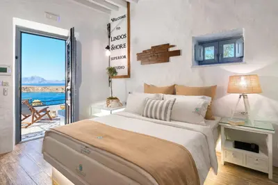 a bedroom with a bed and a view of the ocean at Lindos Shore Superior Studio in Líndos