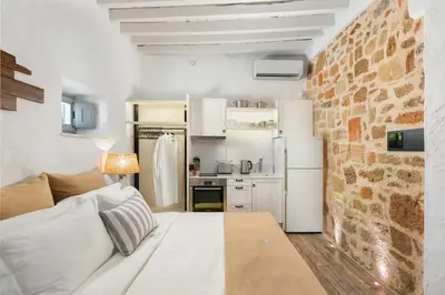 a small kitchen with a white refrigerator in a room at Lindos Shore Superior Studio in Líndos