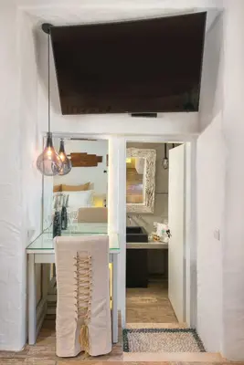a dining room with a glass table and a kitchen at Lindos Shore Superior Studio in Líndos