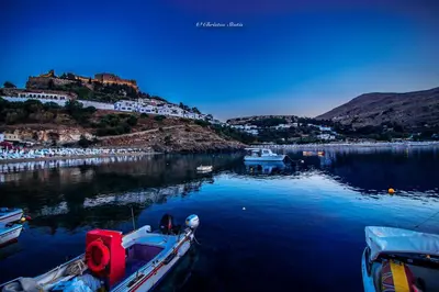 a boat is docked in a body of water at Lindos Shore Superior Studio in Líndos