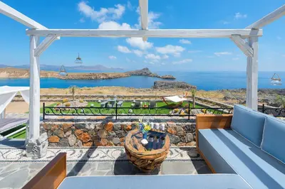 a patio with a bench and a view of the ocean at Lindos Vigli Private Villa in Líndos