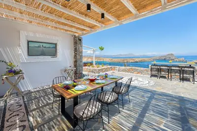 a table on a patio with a view of the ocean at Lindos Vigli Private Villa in Líndos