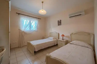 a bedroom with two beds and a window at Athena Villa in Kolimbia