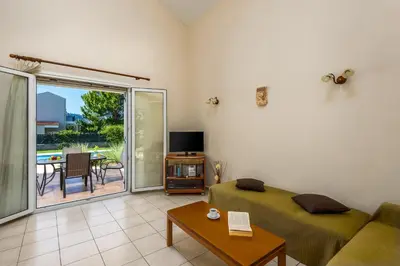 a living room with a couch and a sliding glass door at Athena Villa in Kolimbia