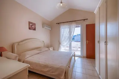 a bedroom with a bed and a sliding glass door at Athena Villa in Kolimbia