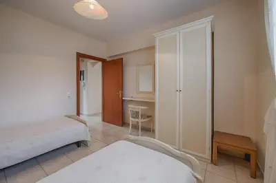 a bedroom with a bed and a closet and a table at Athena Villa in Kolimbia