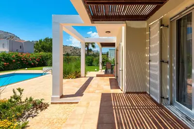 a walkway leading to a house with a pool at Apollo Villa in Kolimbia