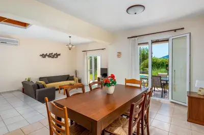 a dining room and living room with a wooden table at Apollo Villa in Kolimbia