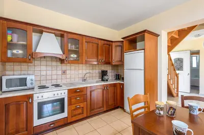 a kitchen with wooden cabinets and a white refrigerator at Apollo Villa in Kolimbia