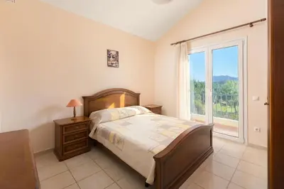 a bedroom with a bed and a large window at Apollo Villa in Kolimbia