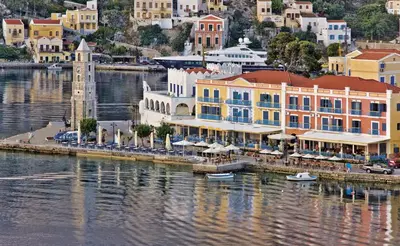 a group of buildings next to a body of water at Nireus Hotel in Symi