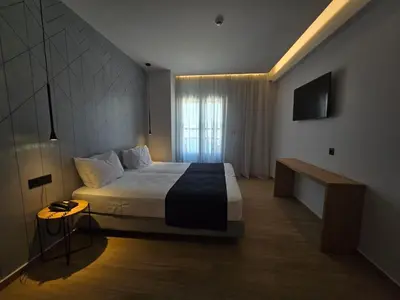 a hotel room with a bed and a television at Nireus Hotel in Symi