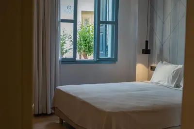 a bedroom with a bed and a window at Nireus Hotel in Symi