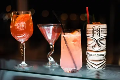 three cocktails on a glass table with at Nireus Hotel in Symi