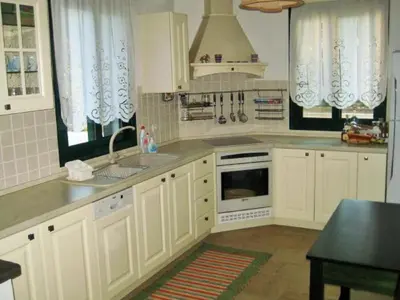 a kitchen with white cabinets and a sink at Villa Akti in Lachania