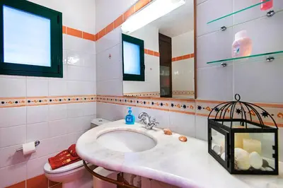 a bathroom with a sink and a toilet and a mirror at Villa Akti in Lachania