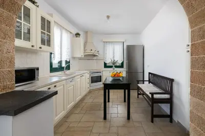 a kitchen with a table and a refrigerator at Villa Akti in Lachania