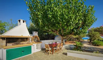 a patio with a table and a tree at Villa Akti in Lachania