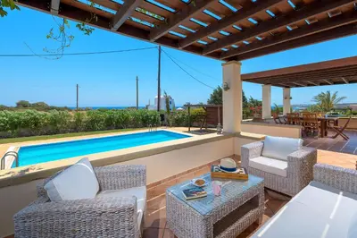 a patio with chairs and a swimming pool at Villa Lahania in Lachania