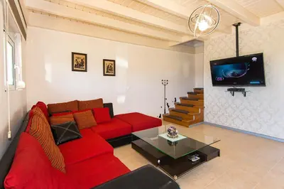 a living room with a red couch and a tv at Kolymbia Villas by StayonRhodes in Kolimbia