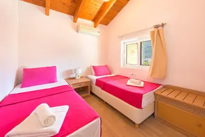 two beds in a room with a window at Kolymbia Villas by StayonRhodes in Kolimbia