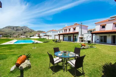 a yard with a table and chairs and a pool at Kolymbia Villas by StayonRhodes in Kolimbia