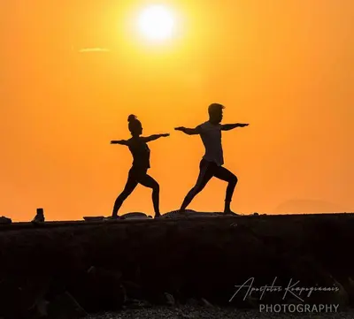 two people running on the beach at sunset at Apartment Dream Holidays - 500 meters to beach in Ialyssos