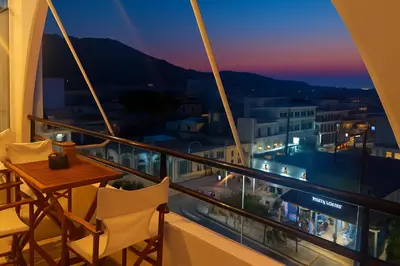 a balcony with a table and chairs overlooking a city at Apartment Dream Holidays - 500 meters to beach in Ialyssos