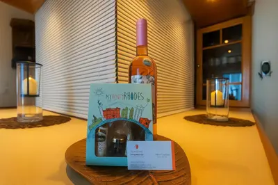 a bottle of wine sitting on top of a table at Apartment Dream Holidays - 500 meters to beach in Ialyssos