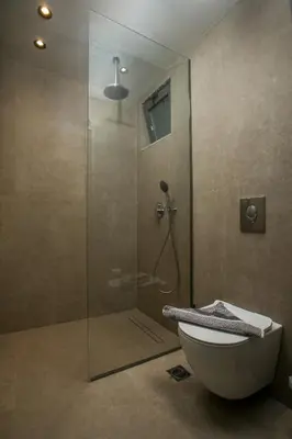 a bathroom with a glass shower with a toilet at Ano Kampos Hotel in Faliraki