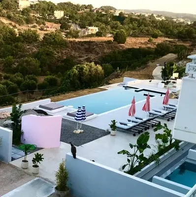 a pool with chairs and umbrellas on top of a building at Ano Kampos Hotel in Faliraki