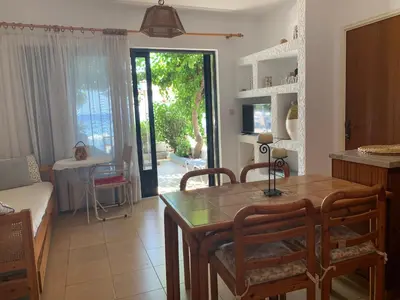 a kitchen and dining room with a table and chairs at Haraki Beach House in Haraki