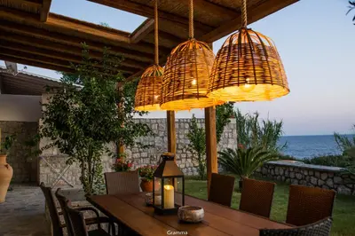 a wooden table with chairs and chandeliers at Villa Sealine in Pefki Rhodes