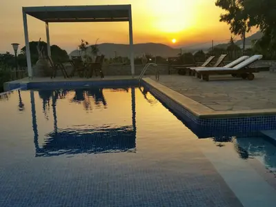 a swimming pool with a sunset in the background at Villa Sealine in Pefki Rhodes