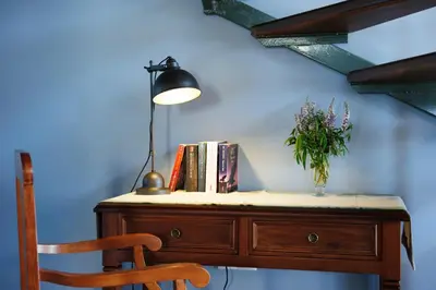 a desk with a vase of flowers and a lamp at Alisahni Beachfront Villas in Kiotari