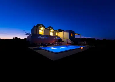 a house with a swimming pool at night at Orianna Sea View Villa in Gennadi