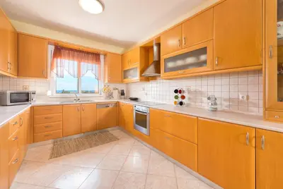 a large kitchen with wooden cabinets and a window at Orianna Sea View Villa in Gennadi