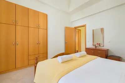 a bedroom with a large bed with wooden cabinets at Orianna Sea View Villa in Gennadi