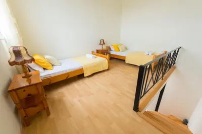a room with two beds and a stair case at Orianna Sea View Villa in Gennadi