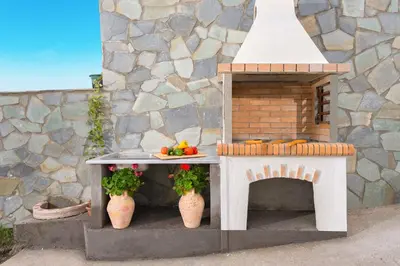 a toy kitchen with a table and a fireplace at Orianna Sea View Villa in Gennadi