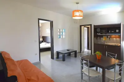 a living room with a table and a dining room at Ialysos City Hotel in Ialyssos