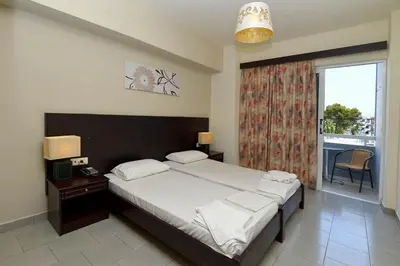 a bedroom with a large bed and a window at Ialysos City Hotel in Ialyssos