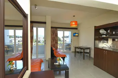 a kitchen and living room with a view of a balcony at Ialysos City Hotel in Ialyssos
