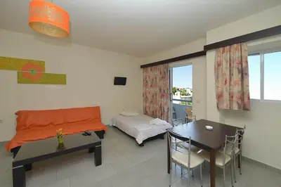 a bedroom with a bed and a desk and a table at Ialysos City Hotel in Ialyssos