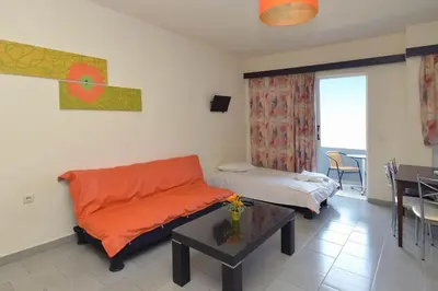 a living room with a couch and a table at Ialysos City Hotel in Ialyssos